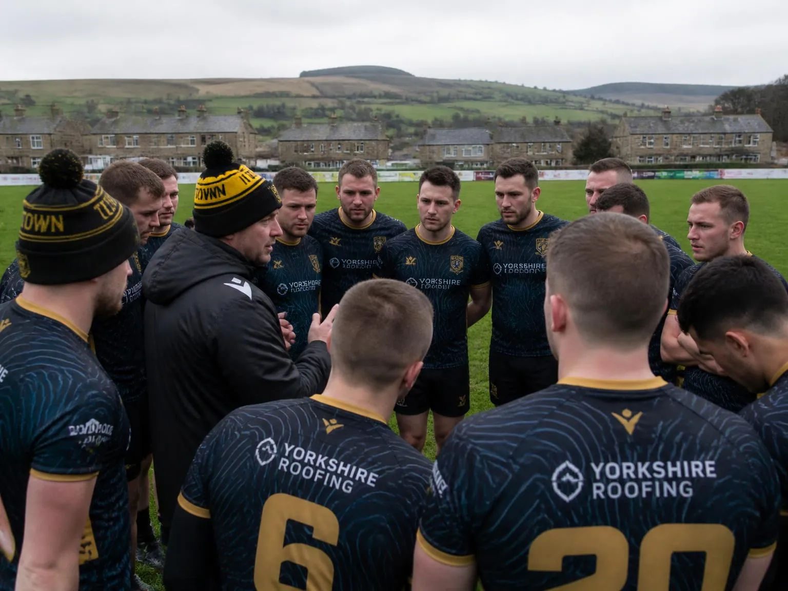Local North Yorkshire sports club team posing on a village pitch in matching branded kits.