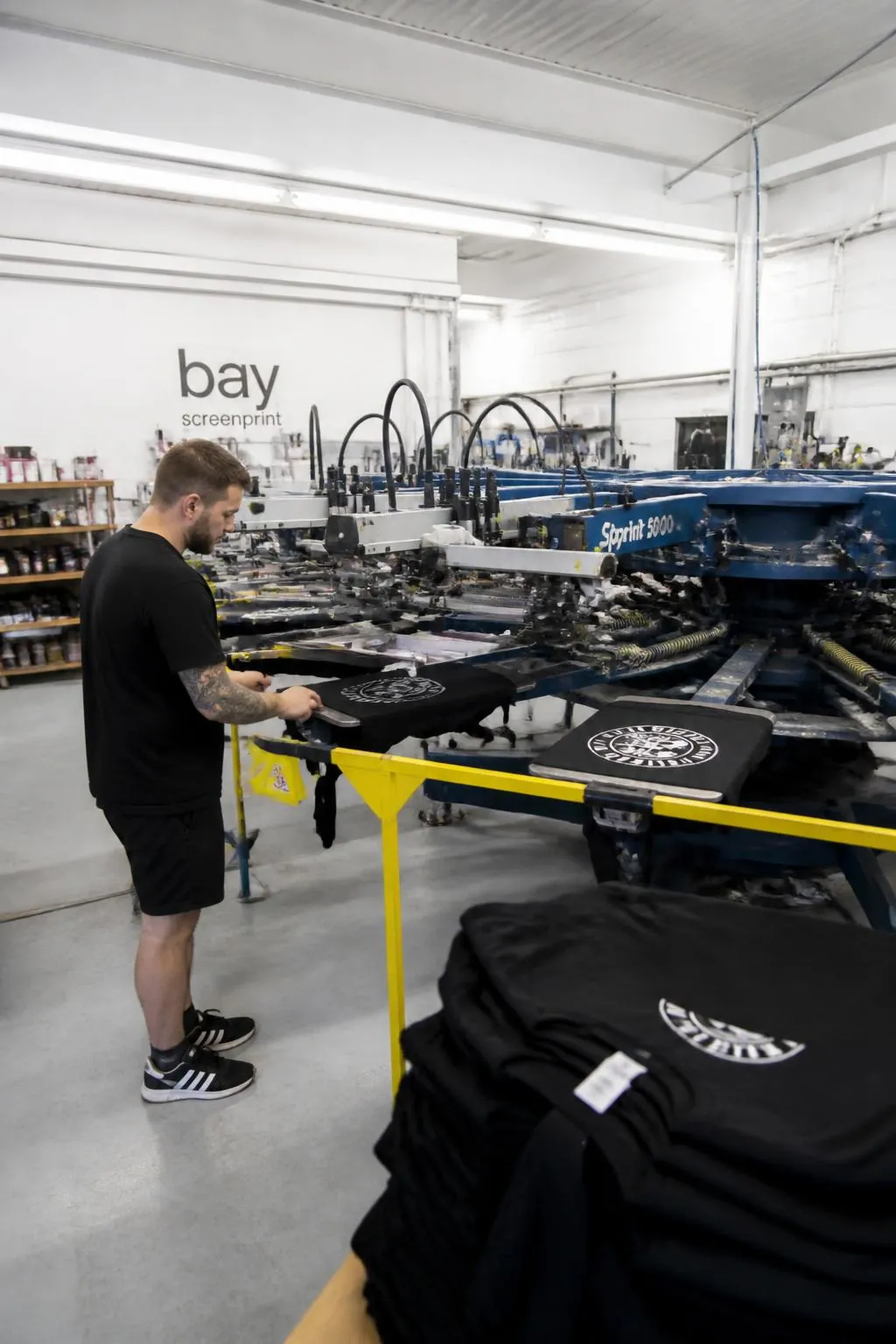 Screen printing carousel printing custom t-shirts in Net-workwear's UK factory.